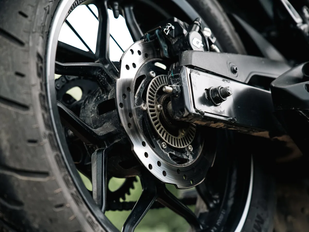 The rear wheel and brake disc of a motorbike.