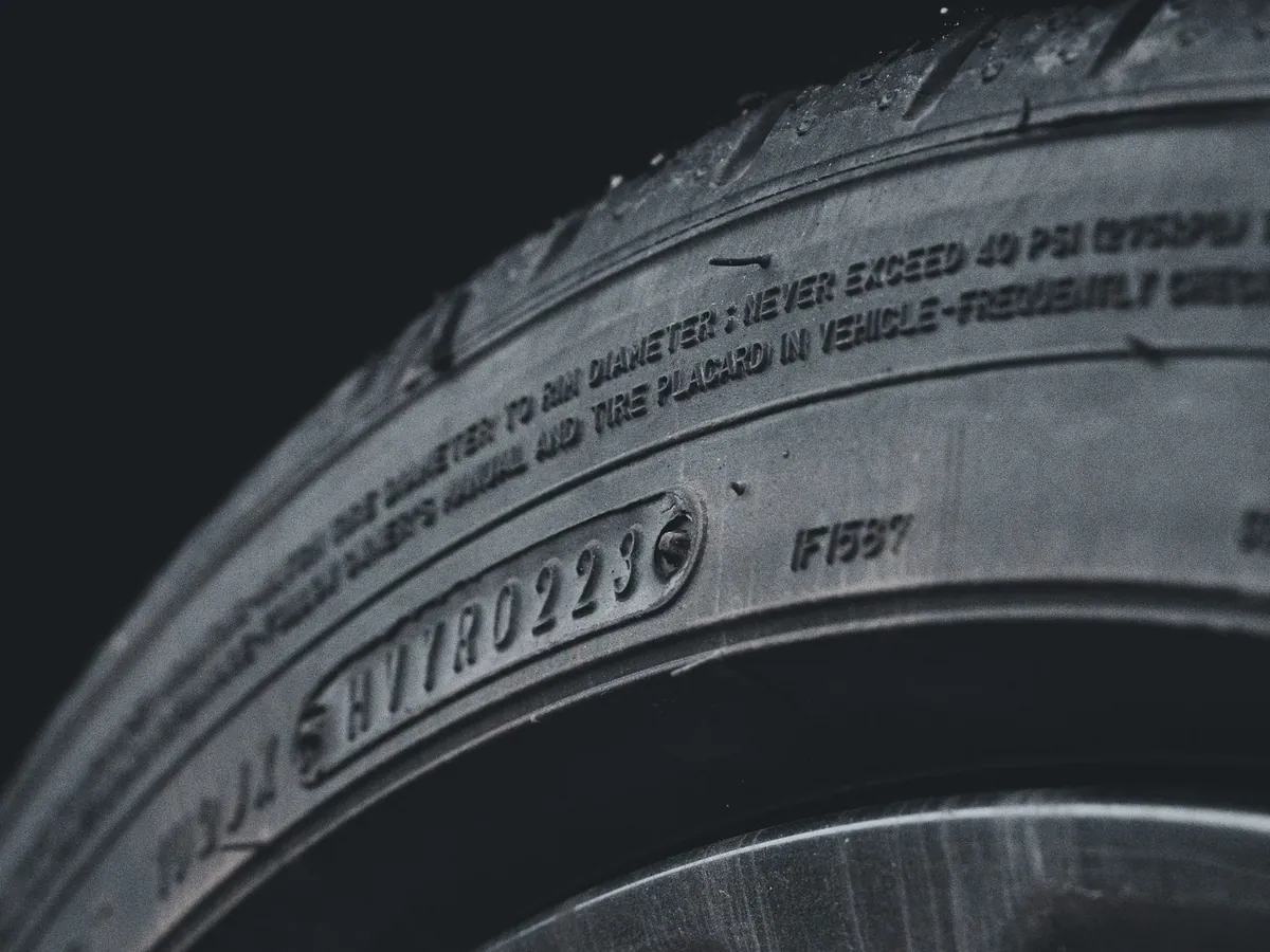 Close-up of the raised lettering moulded into the side wall of a car tyre.