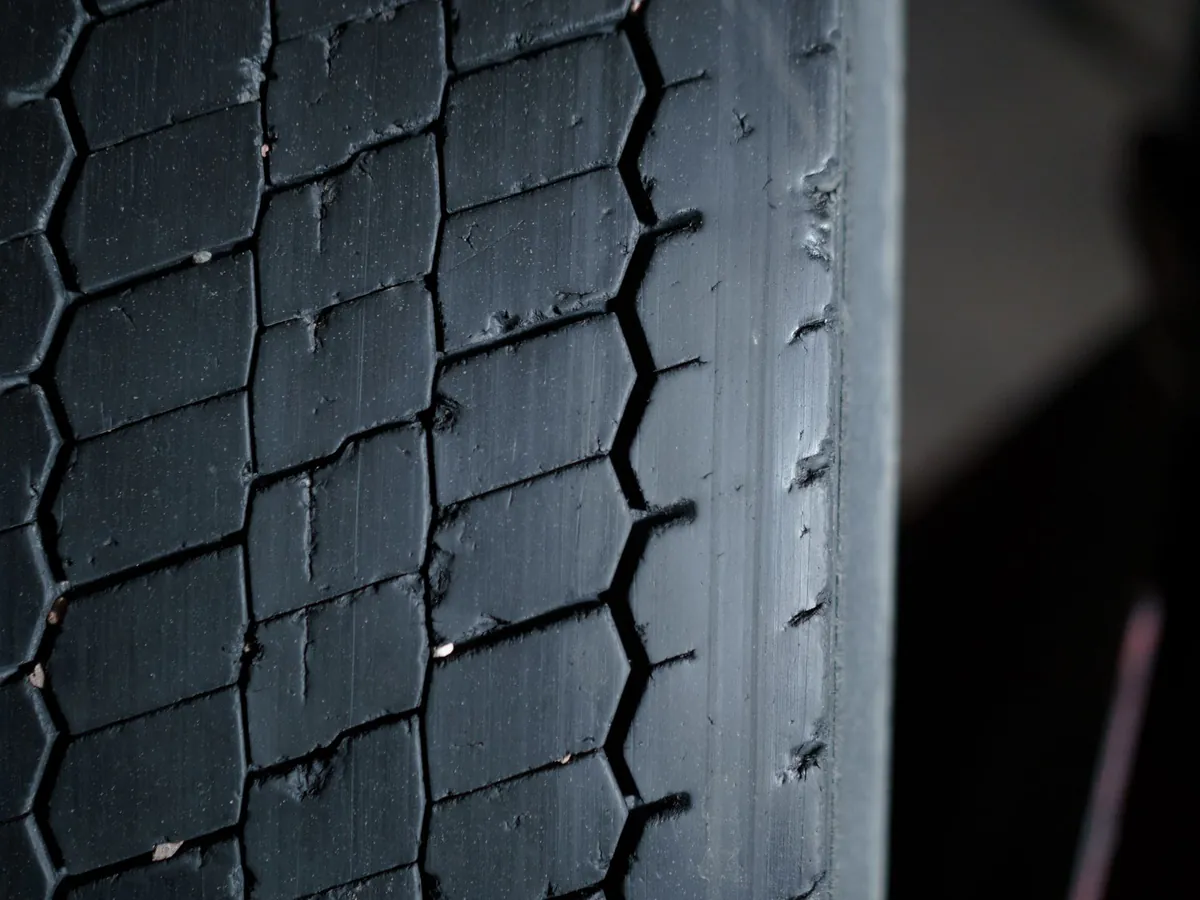 Close-up of a worn tyre tread, showing the grooves and how little depth is left.